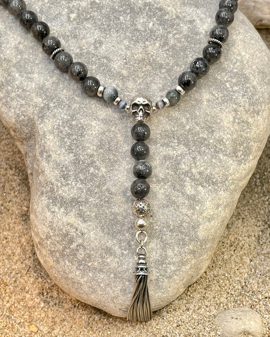 Collier homme BONE TO BE WILD – perles de larvikite de Norvège, perles d’œil d’aigle, tête de mort signature et pompon argent 925