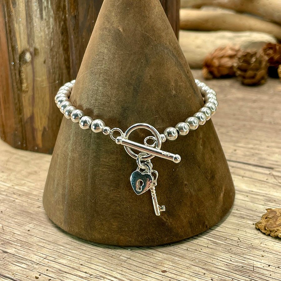 Bracelet femme LOCKED WITH CURBY – perles boules 6 mm & pendentifs clé & cadenas cœur, fermoir toggle et argent 925 – bijoux fait main en argent 925 | Pitch & Néo