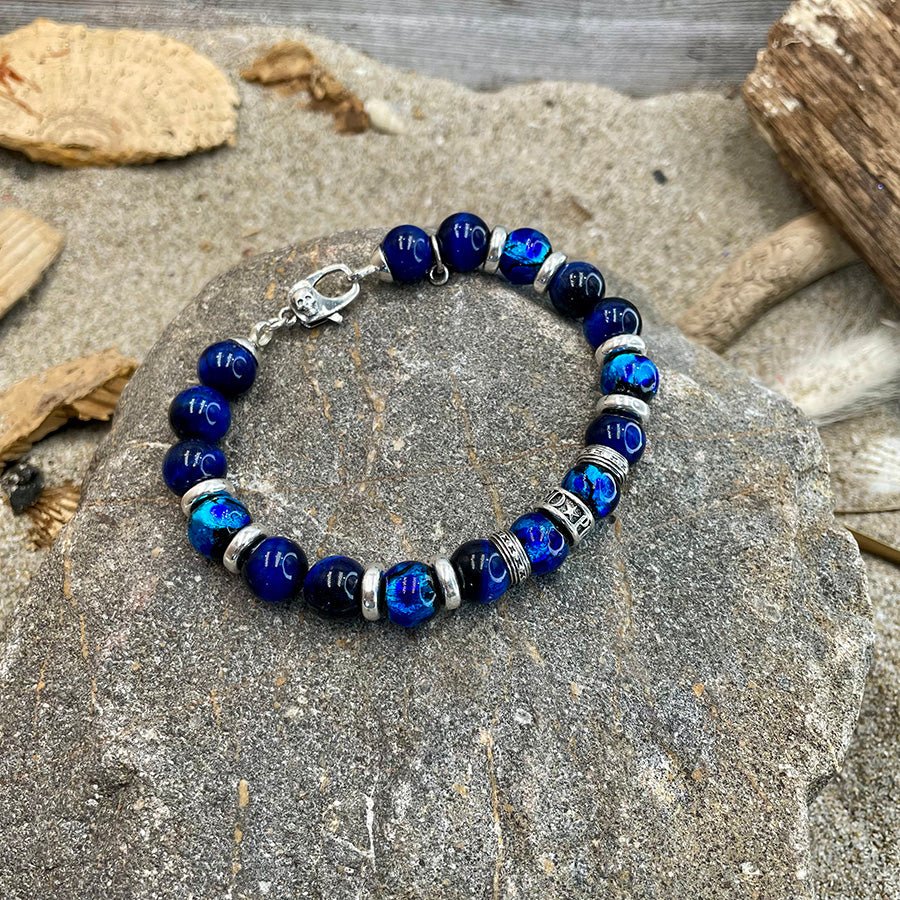 Bracelet homme ABYSS GLOW – perles d’œil de tigre bleu 10 mm, donut signature et fermoir tête de mort argent 925 – bijoux fait main en argent 925 | Pitch & Néo