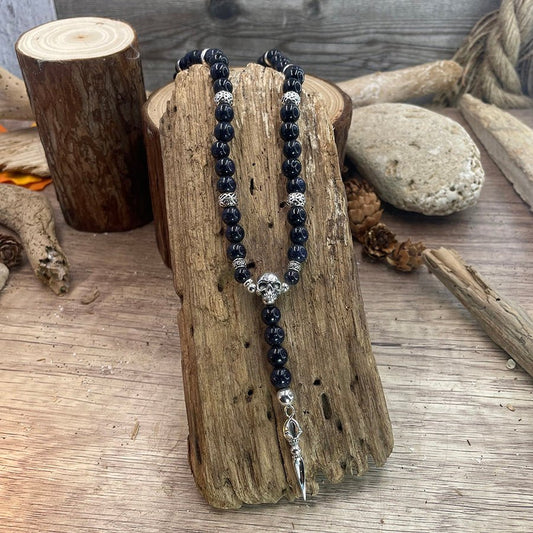 Collier homme COSMIC KILLER – perles de blue sand stone, tête de mort signature, intercalaire ajourés massifs et dague argent 925 – bijoux fait main en argent 925 | Pitch & Néo