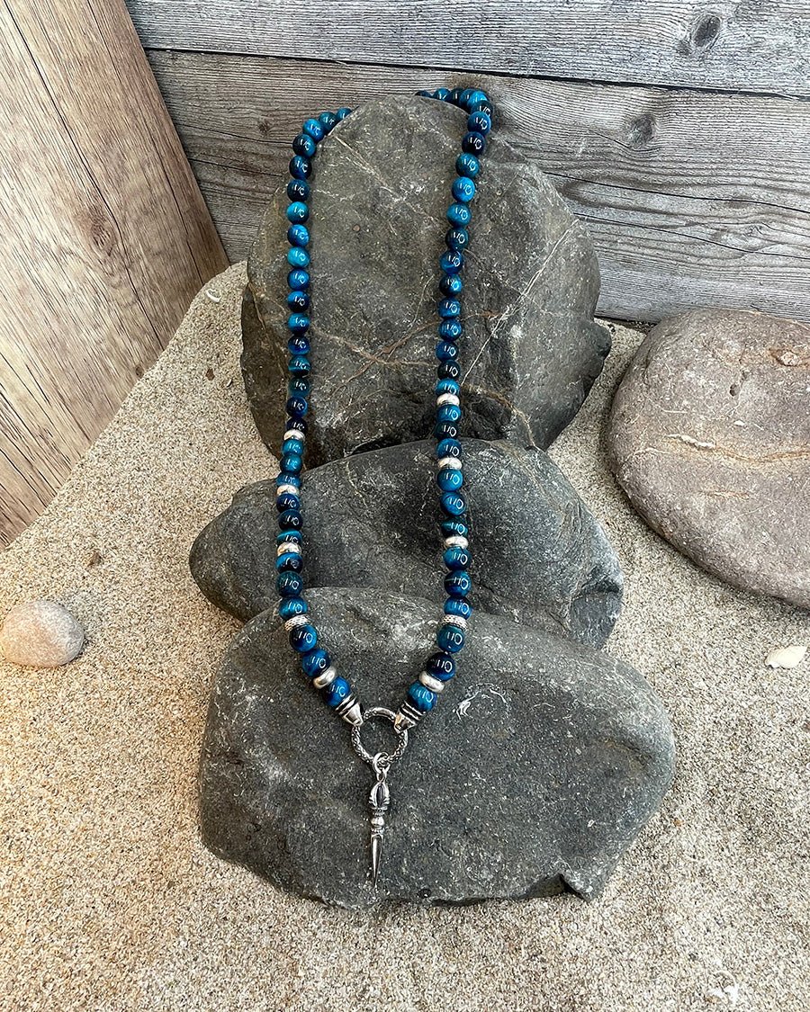Collier homme CUT TO KILL – perles d’œil de tigre bleu lagon, pendentif dague, fermoir mousqueton travaillé et argent 925 – bijoux fait main en argent 925 | Pitch & Néo